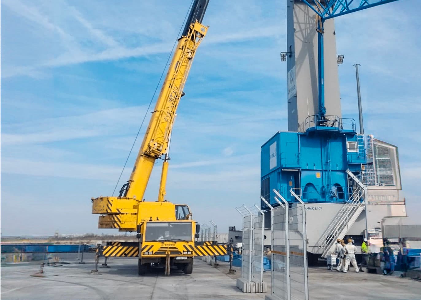 Mobilkran neben einer blauen Industriekonstruktion