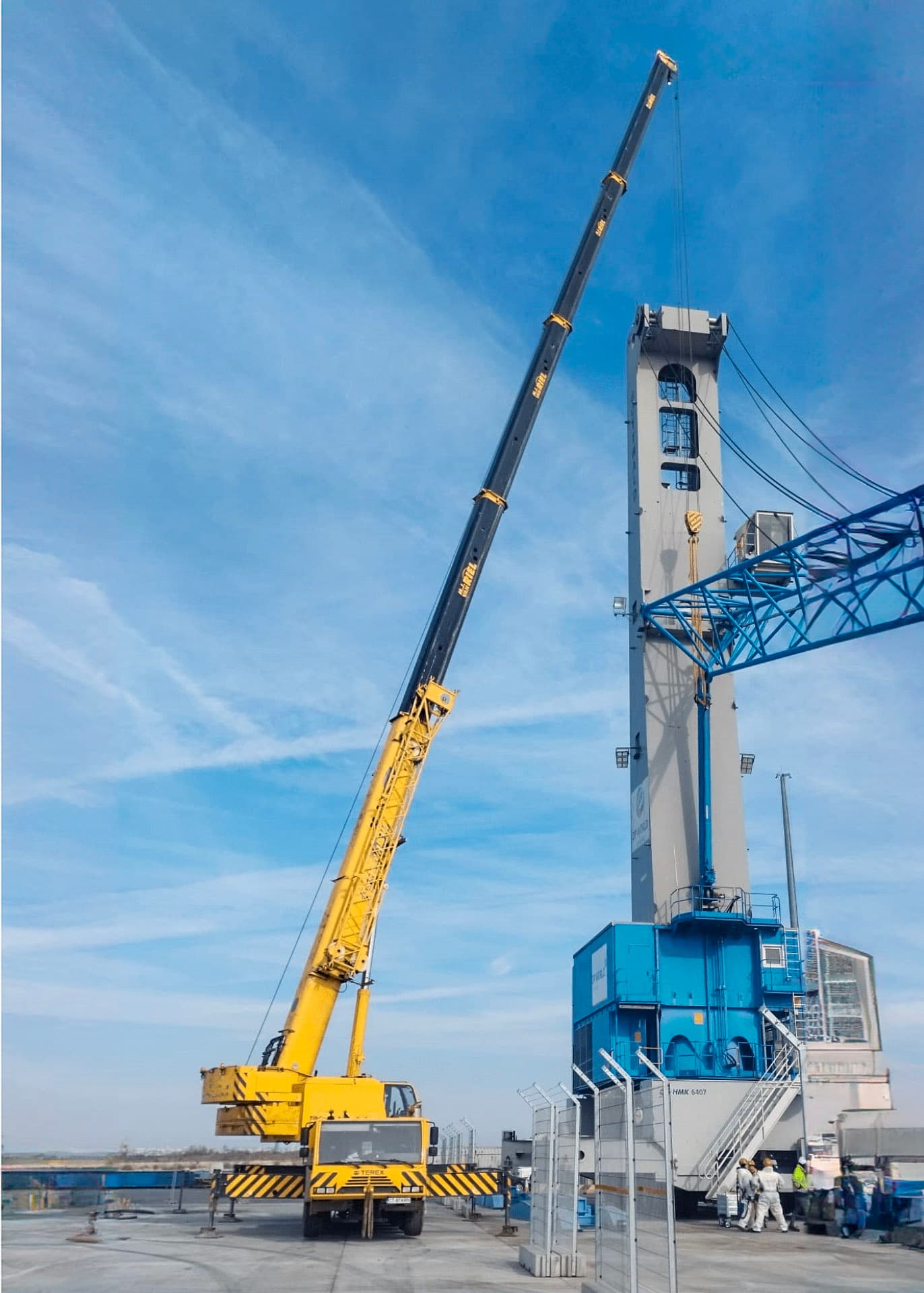Mobilkran neben einer blauen Industriekonstruktion